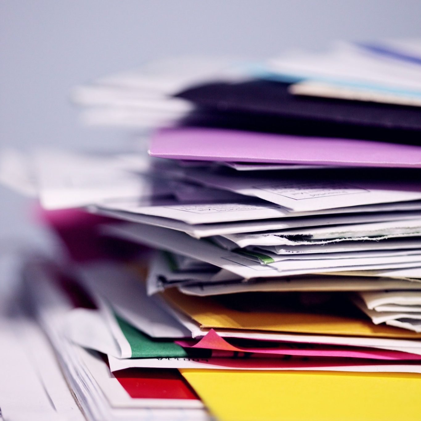 Une pile de papiers et documents colorés en désordre.